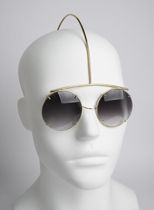 futuristic type of sanglasses worn like a piece of jewelry, golden color 