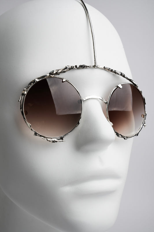 futuristic type of sanglasses worn like a piece of jewelry in silver