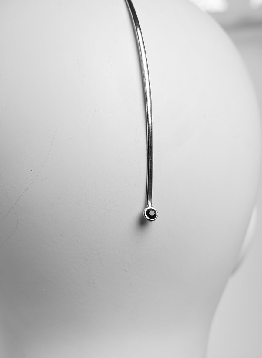 Minimalist silver face jewelry featuring a faceted black crystal 