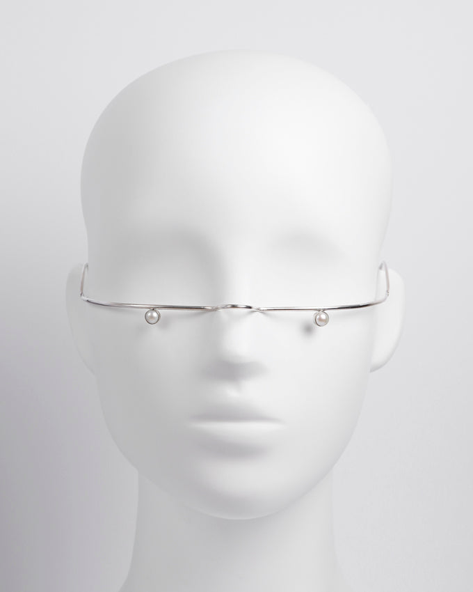 Elegant silver jewelry designed to adorn the face, featuring two small pearls positioned beneath the eyes