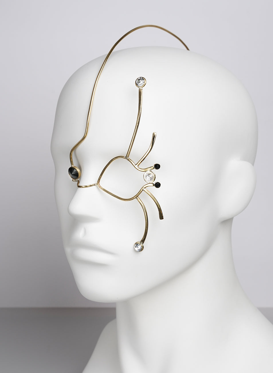 a golden face jewel that adorns the face, eyes, and part of the cheek