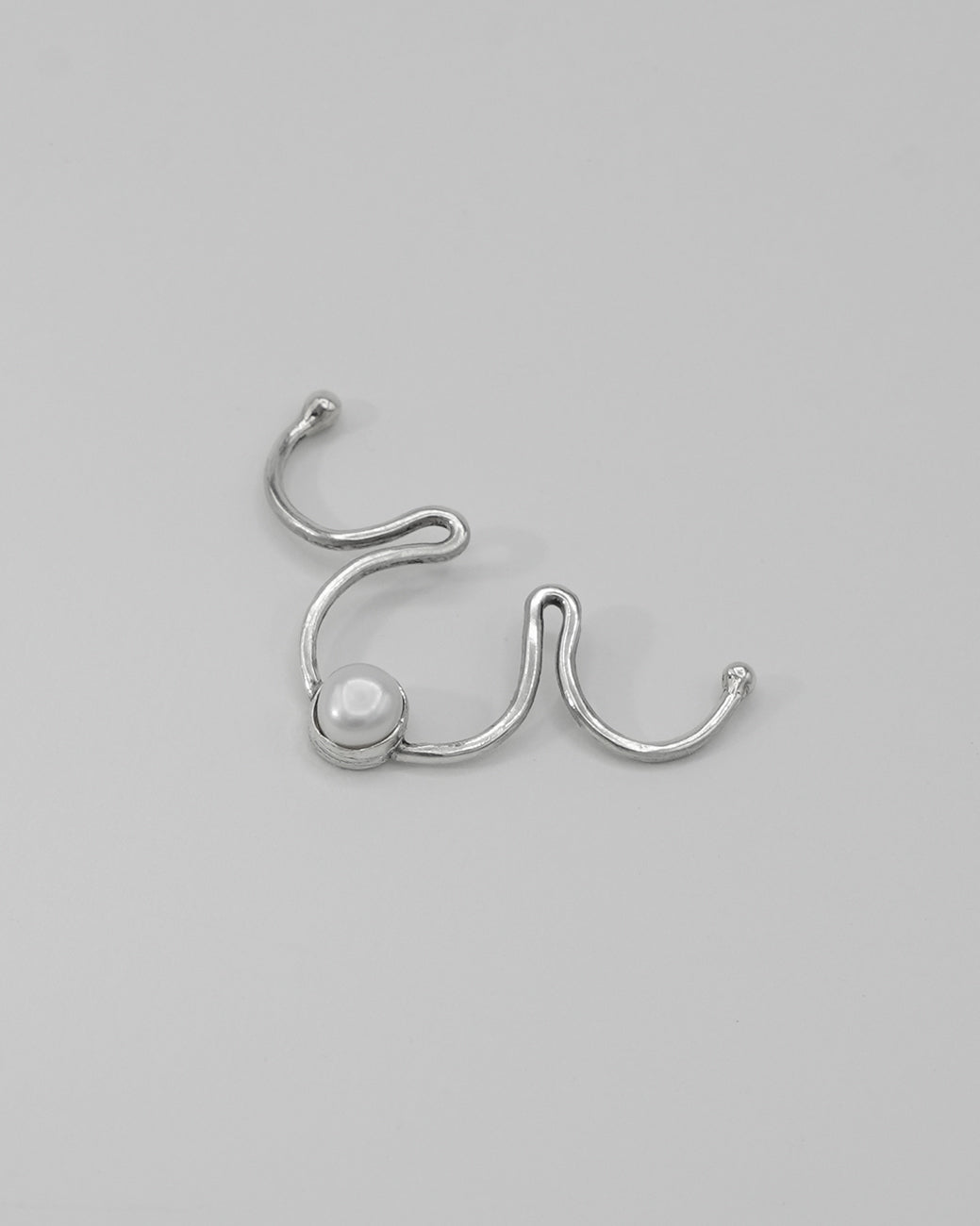 Clip-on silver septum ring jewelry featuring a natural pearl detail.
