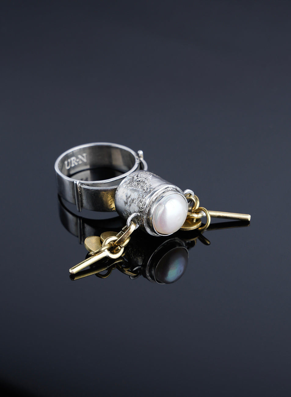 raw silver ring contraste with golden chains and natural pearl