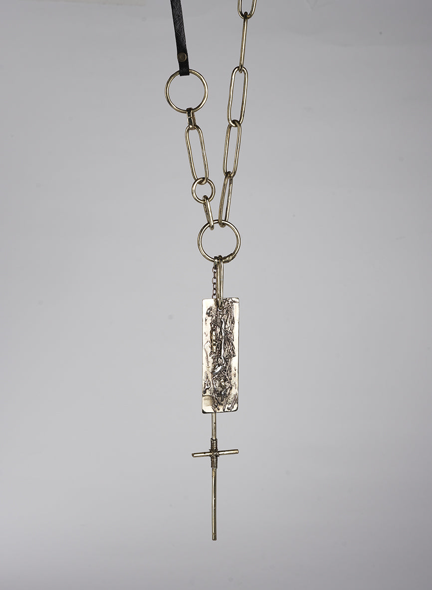 Long necklace made of leather and gold-tone metal with cross pendant and embellishments