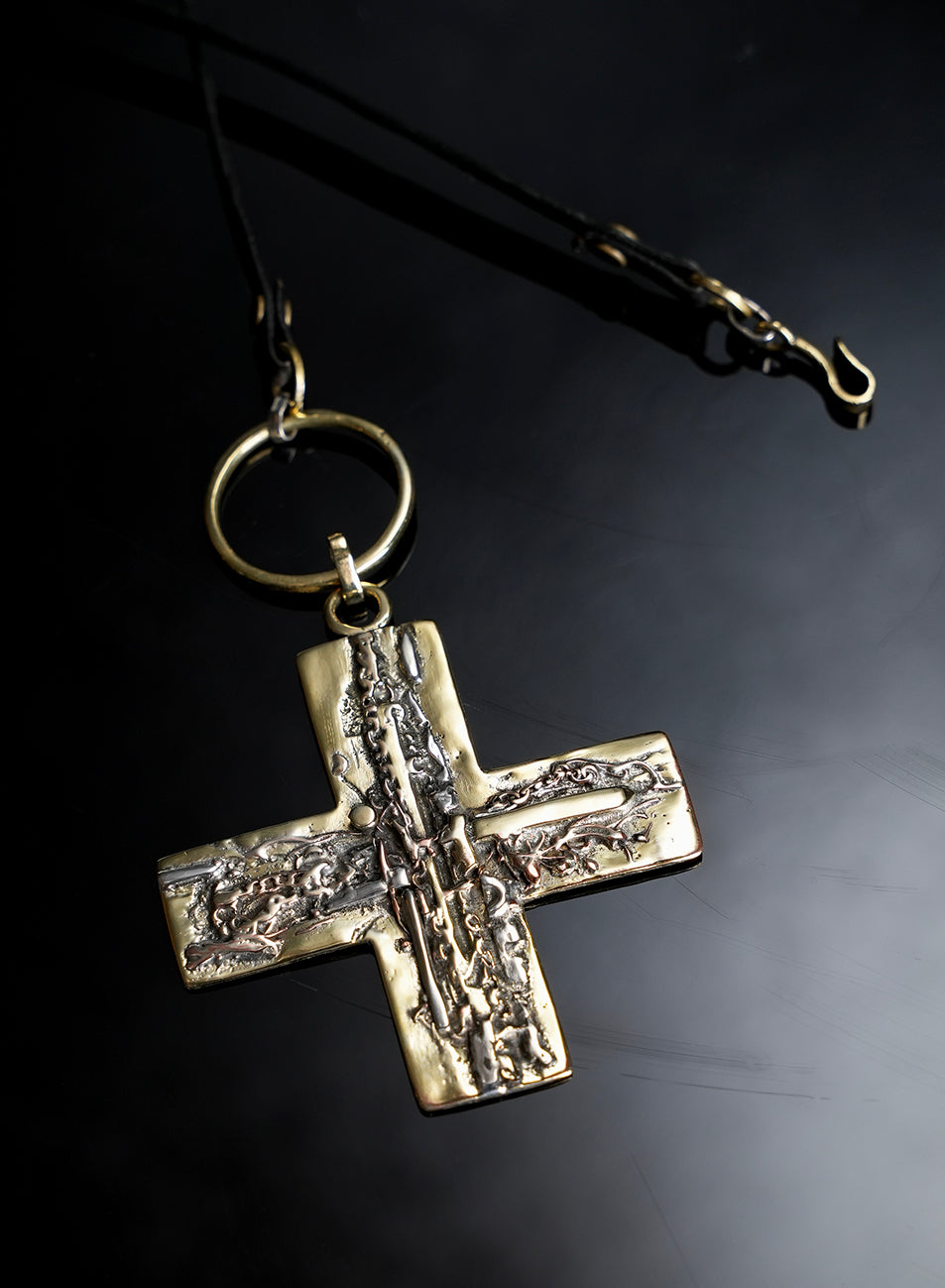 sculptural cross pendant worn on a beautiful handmade long necklace 
