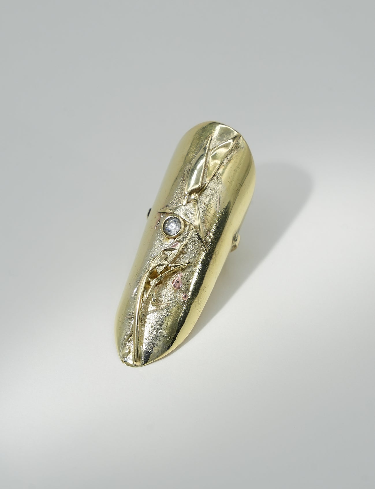 Contemporary sculptural ring in brass and zirconium crystal with artisanal metal fusion texture.