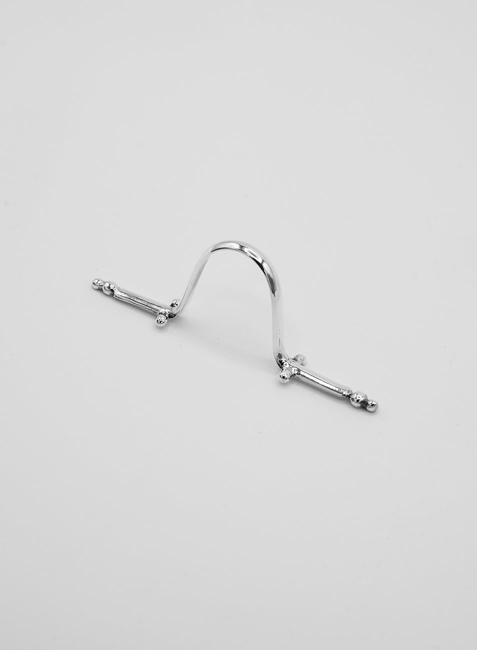 A silver nose ring that sits on the nose; a piercing-free piece featuring beautiful handcrafted details
